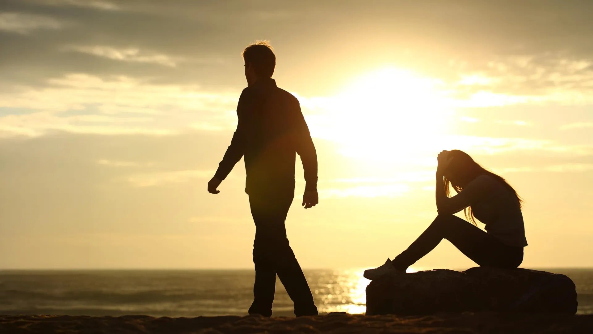 Man walking away from crowd into open landscape